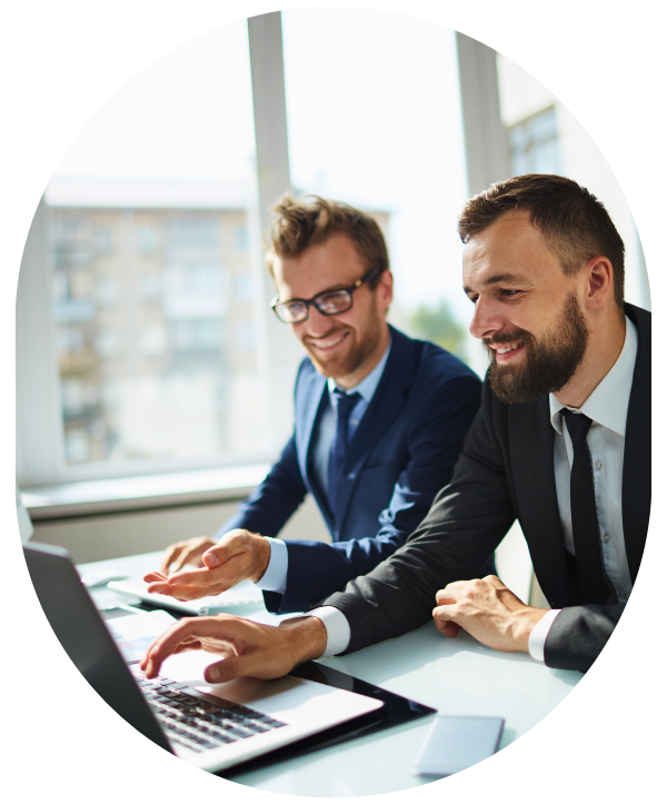 Two smiling men sitting down and looking at a laptop in a bright office. Learn about your compliance obligations for 2025 as a Canadian employer.