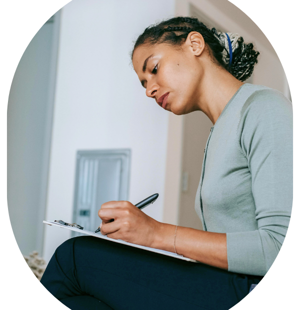 African American woman wearing a light green shirt and black pants is sitting down and writing notes on a clipboard. Title of this web page reads "Terminations Best Practice Guide".