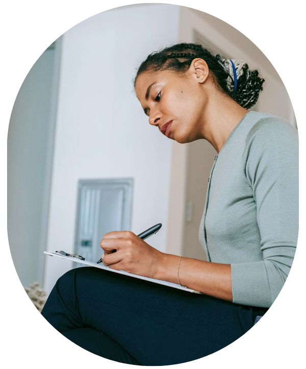 African American woman wearing a light green shirt and black pants is sitting down and writing notes on a clipboard. Title of this web page reads "Terminations Best Practice Guide".