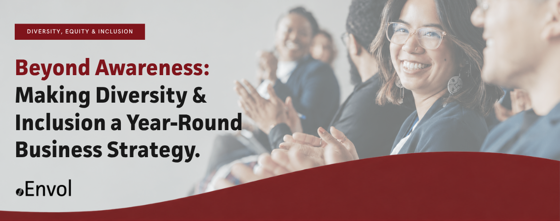Banner image for an Envol blog titled "Beyond Awareness: Making Diversity & Inclusion a Year-Round Business Strategy," featuring a diverse group of professionals applauding at a workplace event, with one smiling woman in the foreground.